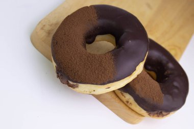 tasty deep fried Donut glazed with chocolate syrup and chocolate powder