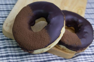 tasty deep fried Donut glazed with chocolate syrup and chocolate powder