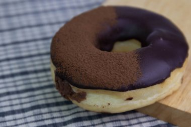 tasty deep fried Donut glazed with chocolate syrup and chocolate powder