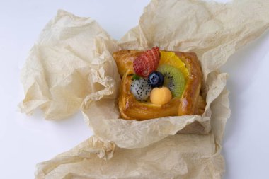 Mixed Fruit Danish Wrapped with Brown Paper on White Background