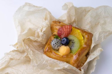 Mixed Fruit Danish Wrapped with Brown Paper on White Background