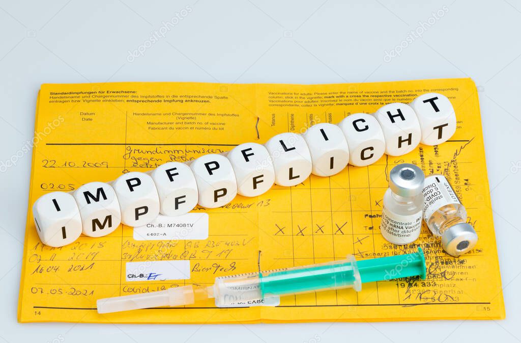 Compulsory vaccination;Syringe with vaccine and International Vaccination Passport. Vaccination written with dice. (Impfen german word for Compulsory vaccination)