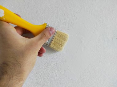 adam fırçayla radyatör boyuyor