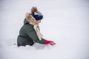 Kız dışarıda bir kardan adam kış zamanında yapar..