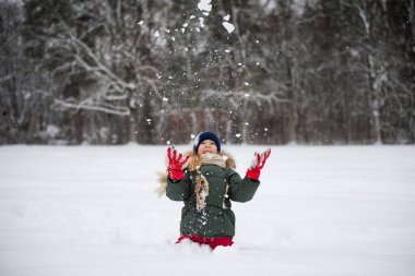 Karlı kış yürüyüşünde karla kaplı mutlu bir kız çocuğu..