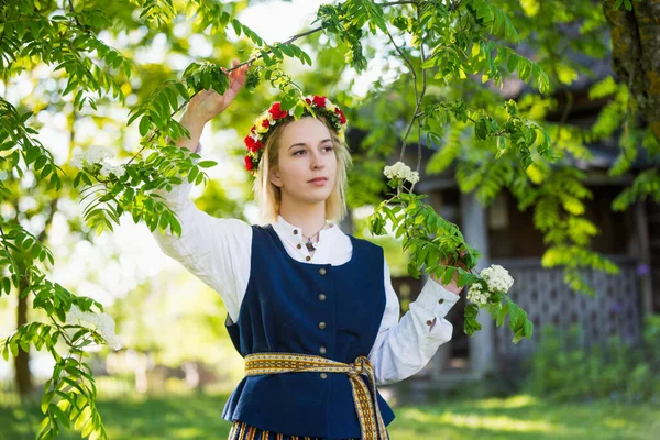 Donna in abbigliamento tradizionale posa sulla natura nel villaggio. — Foto Stock