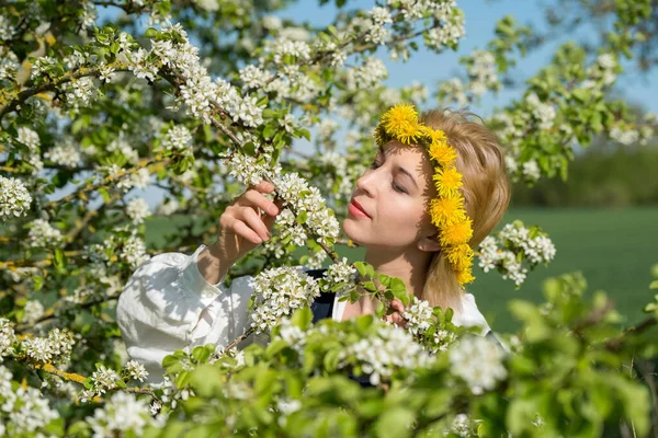 Mulher feminina bonita em vestido nacional com flores brancas da primavera — Fotografia de Stock