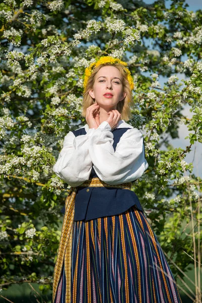 Schöne feministische Frau im Nationalkleid mit weißen Frühlingsblumen — Stockfoto