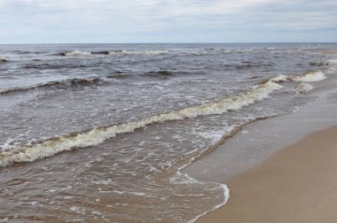 Baltık Denizi. Letonya 'nın kumlu sahillerinde deniz ve dalgalar