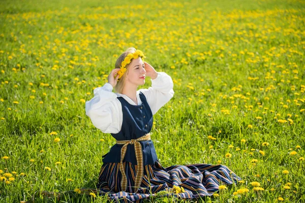 Young woman in national clothes wearing yellow dandelion wreath in spring field. Ligo — Stock Photo, Image