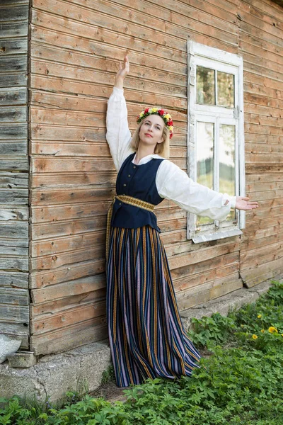 Donna in abbigliamento tradizionale posa sulla natura nel villaggio. — Foto Stock