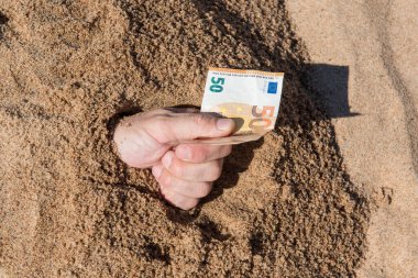 Kumdan çıkmış bir adamın elinde 50 euro var. Finans parası tatili kavramı.