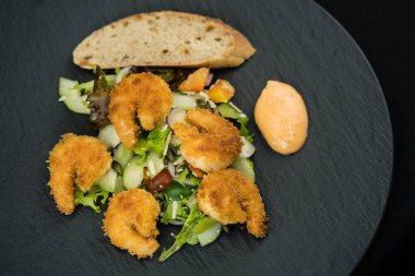 Çıtır ekmek ve salatalı kızarmış karides.