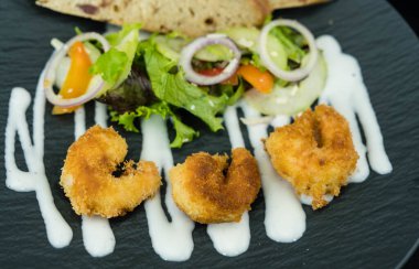 Çıtır ekmek ve salatalı kızarmış karides.