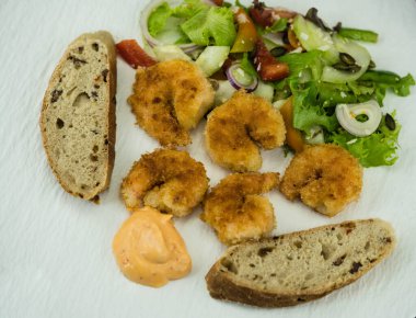 Çıtır ekmek ve salatalı kızarmış karides.