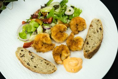 Çıtır ekmek ve salatalı kızarmış karides.