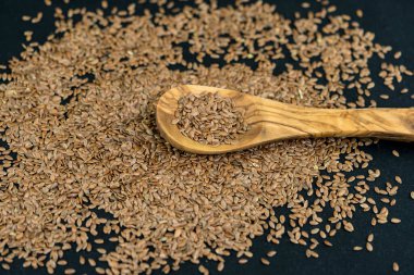 Bir yığın keten tohumu ve zeytin ağacından yapılmış kap kacak.