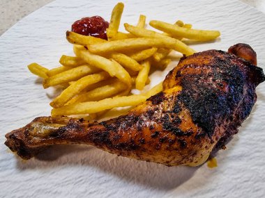 Patates kızartmalı baharatlı tavuk budu.