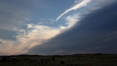 Beyaz ve gri bulutların açık çayırdaki bir kamp alanının üzerindeki izleyiciye doğru ilerlemesi zaman aldı.