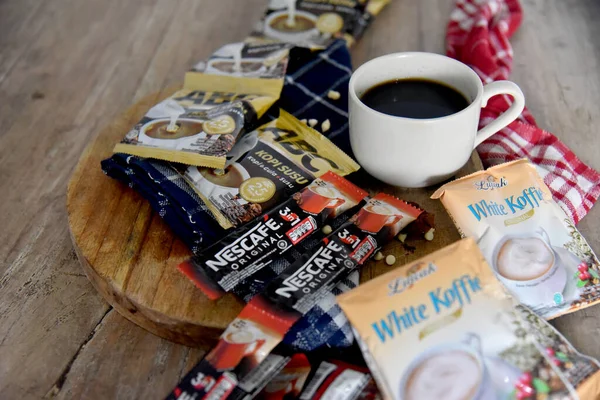 BALI, INDONEZYA-SEPTEMBER 09 2021: Ahşap masaya yerleştirilmiş bir çok boş kahve markasının ortasında bir fincan kahve, çoğunlukla Endonezya 'daki tatil beldelerinden alınmış gibi görünüyor. 