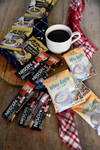 BALI, INDONEZYA-SEPTEMBER 09 2021: Ahşap masaya yerleştirilmiş bir çok boş kahve markasının ortasında bir fincan kahve, çoğunlukla Endonezya 'daki tatil beldelerinden alınmış gibi görünüyor. 