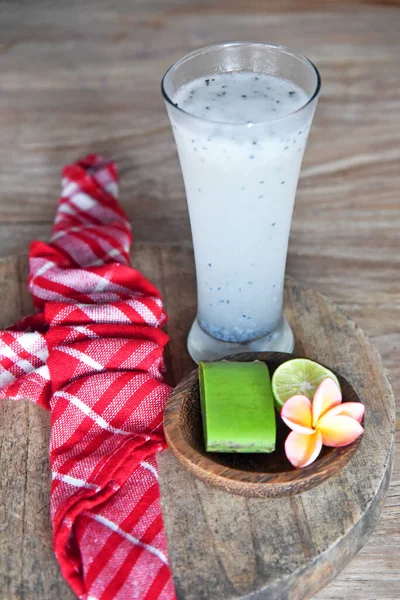 Kahverengi ahşap masaya yerleştirilmiş Aloe Vera suyu.