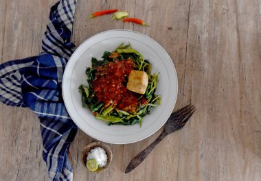 Su Ispanağı sebzeleri Endonezya dilinde kahverengi ahşap masaya yerleştirilmiş 