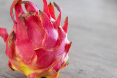 Kahverengi ahşap masaya yakın çekimde renkli ejderha meyvesi yerleştirildi.