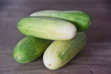 Kahverengi ahşap masaya konmuş salatalık.