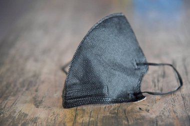 Siyah maske, kahverengi ahşap masaya.