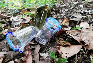 Bali, Endonezya - 12 Nisan 2022: Doğada yere bırakılmış plastik su mineral camı