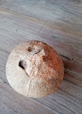 Kahverengi ahşap arka plana yerleştirilmiş eski hindistan cevizi meyvesi.