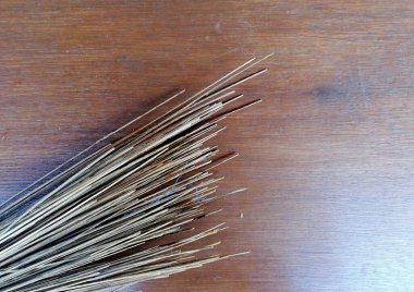 Süpürge sapı kahverengi ahşap masaya yerleştirilmiş.