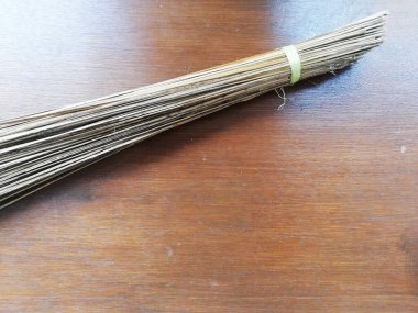 Süpürge sapı kahverengi ahşap masaya yerleştirilmiş.