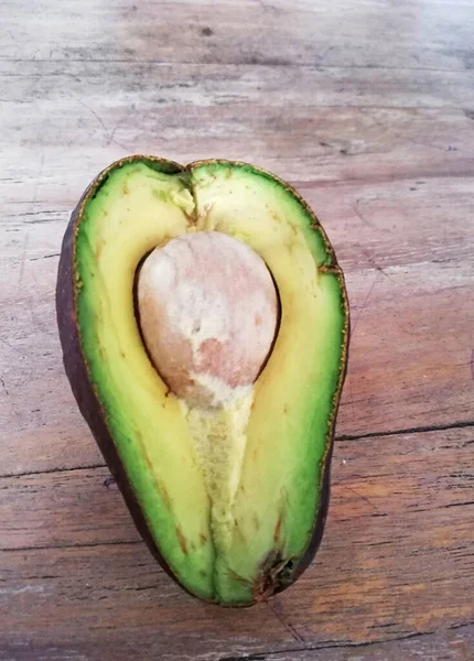 Frisch Geöffnete Abgeschnittene Avocadofrucht Auf Braunem Holzgrund — Stockfoto