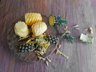 Sevimli, ananaslı, kahverengi ahşap arka plana yerleştirilmiş.