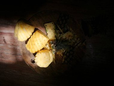 Sevimli, ananaslı, kahverengi ahşap arka plana yerleştirilmiş.