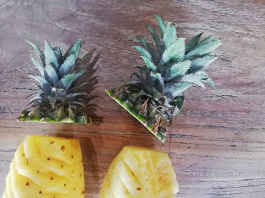 Sevimli, ananaslı, kahverengi ahşap arka plana yerleştirilmiş.