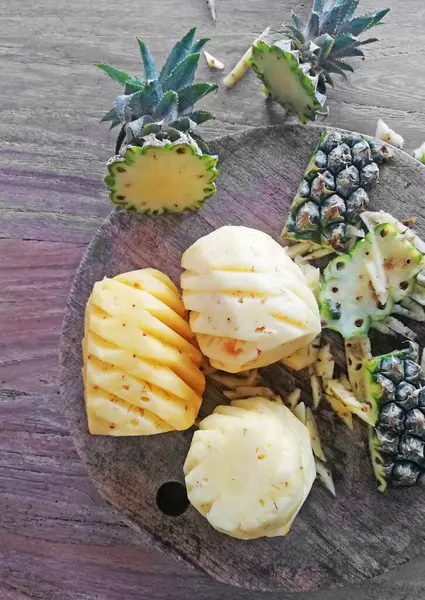 Sevimli, ananaslı, kahverengi ahşap arka plana yerleştirilmiş.