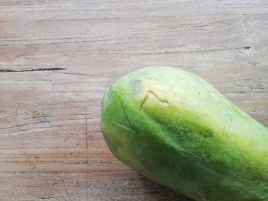 Kahverengi ahşap masaya yerleştirilmiş taze papaya meyvesi.