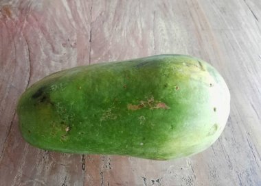 Kahverengi ahşap masaya yerleştirilmiş taze papaya meyvesi.