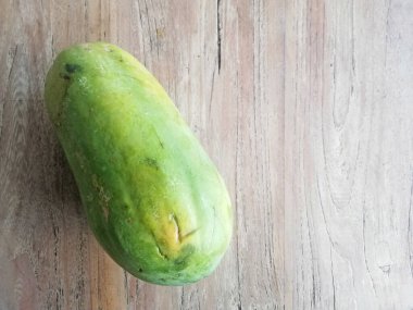 Kahverengi ahşap masaya yerleştirilmiş taze papaya meyvesi.