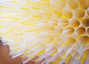 Ahşap zemin üzerinde beyaz ve sarı renkli plastik strow 