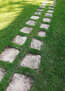 Bahçede yere yerleştirilmiş bir taş bloğu.