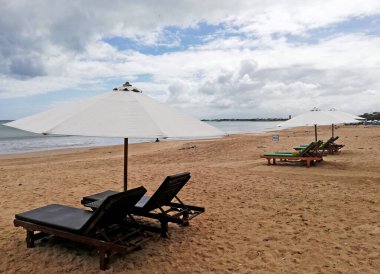 Bali Endonezya 'daki güzel Jimbaran plajı, güzel havalarda beyaz kum ve güneş yatağı