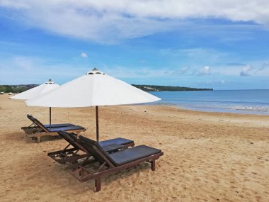 Bali Endonezya 'daki güzel Jimbaran plajı, güzel havalarda beyaz kum ve güneş yatağı