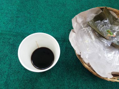 The rest of cup of coffee and cakes placed on traditional plate,isolated on green carpet background