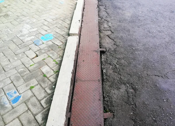 Drainage system at the road,with metal material cover