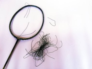Bali,Indonesia - July 23,2022: Badminton racket with a broken strings,on color background