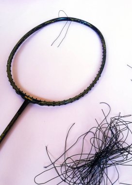 Bali,Indonesia - July 23,2022: Badminton racket with a broken strings,on color background